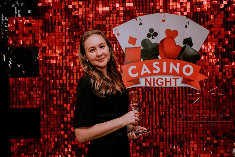 Фотозона из красно-чёрных пайеток в оформлении корпоративной вечерники в стиле "Казино"